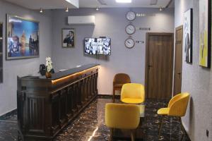 a waiting room with a bar with yellow chairs at The Hotel Syracuse in Casablanca