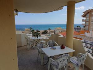 a balcony with tables and chairs and a view of the ocean at Bitacora I Solo Familias Serviplaya!!! in Playa de Xeraco