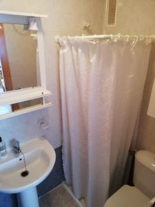 a bathroom with a white shower curtain and a sink at Bitacora I Solo Familias Serviplaya!!! in Playa de Xeraco +17 photos