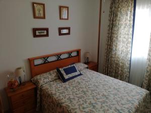 a bedroom with a bed with a blue pillow on it at Bitacora I Solo Familias Serviplaya!!! in Playa de Xeraco