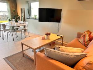 a living room with a couch and a table at Apartment with garden and sea view in Haugesund