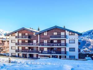 a large building with snow in front of it at Apartment Anemone 9 by Interhome in Nendaz