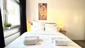 a bedroom with a large white bed with white pillows at Modern Central Apartments near Hbf & Messe Essen in Essen +93 photos