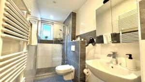 a white bathroom with a sink and a toilet at Helbings Apartments Essen in Essen