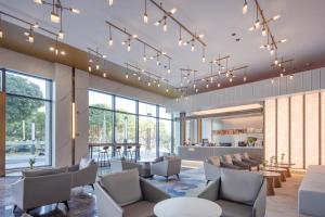 a waiting room with chairs and tables and lights at Zhuhai New Aolin Apartment - Tangjiawan Station in Zhuhai
