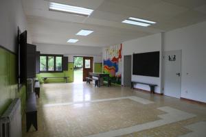 um quarto com uma grande sala com uma televisão e uma mesa em Casa de Colònies Vall de Boí - Verge Blanca em Llesp