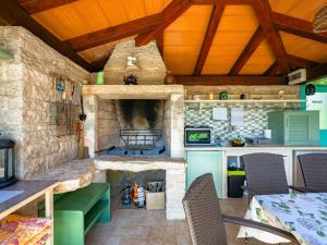 a kitchen with a stone fireplace in a room at Apartment Pina by Interhome in Tinjan +26 photos