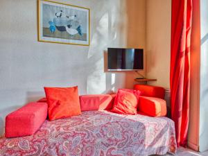 Una sala de estar con un sofá rojo y un televisor. en Apartment Hameau du golf-2 by Interhome, en Lacanau-Océan