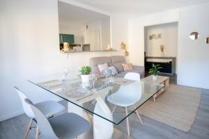 a living room with a glass table and white chairs at Luminous apartment with balcony - Allées Provençales in Aix-en-Provence