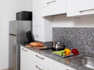 a kitchen with a sink and a counter top with vegetables at Apartment MB4 Loggia by Interhome in Moriani Plage +26 photos