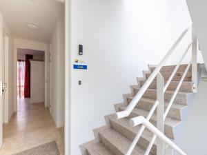 a staircase in a house with white walls and white stairs at Apartment De Zeeparel by Interhome in Egmond aan Zee