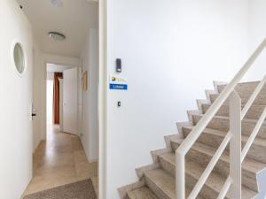 a staircase in a home with white walls and a stair case at Apartment De Zeeparel by Interhome in Egmond aan Zee