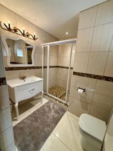 a bathroom with a shower and a toilet and a sink at Simanya River Lodge in Kanyekama