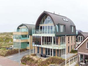 a large building with a metal roof at Apartment De Zeeparel by Interhome in Egmond aan Zee