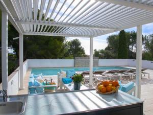 eine weiße Pergola über einem Tisch mit einer Schüssel Orangen in der Unterkunft Holiday Home Nelli by Interhome in Calpe