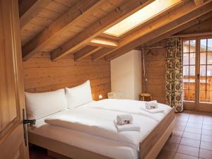 a bedroom with a large white bed in a attic at Apartment Chalet Pfingstrose by Interhome in Grindelwald