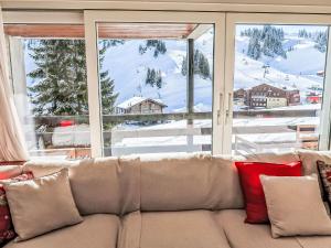 um sofá com almofadas numa sala de estar com uma janela em Apartment Les Cimes by Interhome em Les Crosets