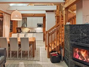 eine Küche und ein Esszimmer mit einem Kamin in der Unterkunft Holiday Home Tinttityy by Interhome in Tahkovuori