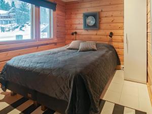 ein Schlafzimmer mit einem Bett in einer Blockhütte in der Unterkunft Holiday Home Tinttityy by Interhome in Tahkovuori + 16 Fotos