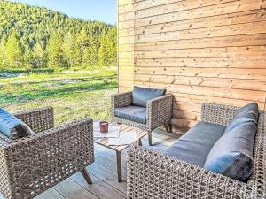 a patio with wicker furniture and a wooden wall at Holiday Home Tiny Haus Glockenalm-Haus Spitzingsee by Interhome in Aurach