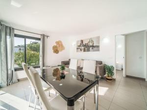 Un comedor con una mesa de cristal y sillas blancas. en Apartment Oratge Beach Views by Interhome, en Puerto Pollensa
