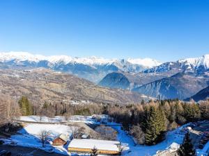 een huis met uitzicht op een besneeuwde bergketen bij Apartment Baikonour-7 by Interhome in Le Corbier