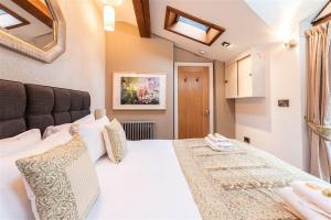 une chambre avec un grand lit blanc et un miroir dans l'établissement Central Two Bed Cottage On Watergate Street by Cheshire Escapes, à Chester