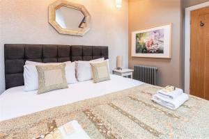 une chambre avec un grand lit avec un miroir au mur dans l'établissement Central Two Bed Cottage On Watergate Street by Cheshire Escapes, à Chester