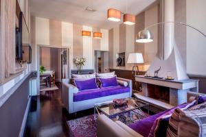 a living room with a purple couch and a fireplace at The Inn at the Spanish Steps Luxury Collection - The Inn at the Spanish Steps in Rome +166 photos