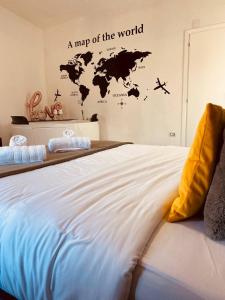 a large bed with a map of the world on the wall at G-house in Parma