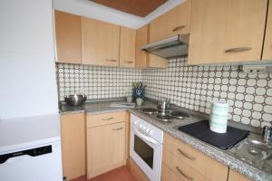 a kitchen with wooden cabinets and a white stove top oven at Parkside - 24h Self Check - in - bis 5 Personen - Nähe Saarlouis - Wifi - Parken - ganze Haus in Ensdorf +8 photos