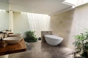 a bathroom with two sinks and two toilets at Anandathu Villas in Canggu