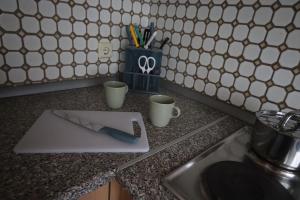 a knife on a cutting board on a kitchen counter at Parkside - 24h Self Check - in - bis 5 Personen - Nähe Saarlouis - Wifi - Parken - ganze Haus in Ensdorf