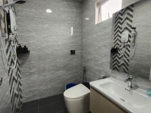 a bathroom with a toilet and a sink at Ujong Pasir 4BR Moden House in Melaka +71 photos