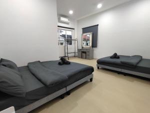 a bedroom with two beds and a mirror on the wall at Ujong Pasir 4BR Moden House in Melaka