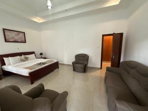 a bedroom with a bed and a couch and a chair at Kibagabaga 5 - Bedroom Villa in Kigali +24 photos