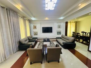 a large living room with couches and a tv at Kibagabaga 5 - Bedroom Villa in Kigali