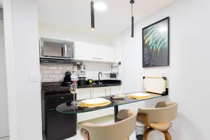 Una cocina con una mesa y sillas en una habitación. en Studio Praia do jardim 1 205A, en Angra dos Reis 12 fotos más