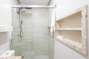 Un baño con ducha con puerta de cristal. en Studio Praia do jardim 1 205A, en Angra dos Reis