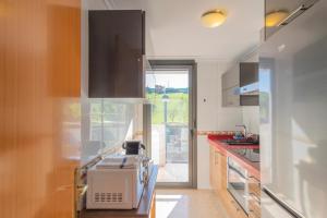 eine Küche mit Mikrowelle und Fenster darin in der Unterkunft Apartamento Holidea Mogro in Miengo + 14 Fotos