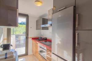 eine Küche mit Edelstahlkühlschrank und Fenster in der Unterkunft Apartamento Holidea Mogro in Miengo