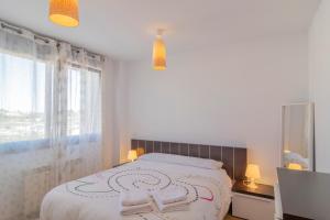 ein weißes Schlafzimmer mit einem Bett und einem Fenster in der Unterkunft Apartamento Holidea Mogro in Miengo