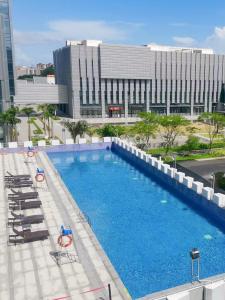 an overhead view of a pool with chairs and a building at Zhuhai New Aolin Apartment - Tangjiawan Station in Zhuhai