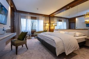 ein großes Schlafzimmer mit einem großen Bett und einem Stuhl in der Unterkunft Insel-Hotel Heilbronn in Heilbronn