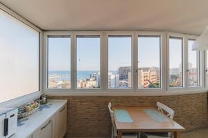 a kitchen with a table and views of the ocean at Wow Waterfront Apartment in Bari