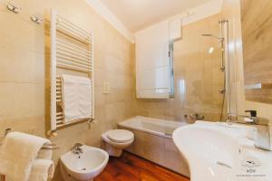 a bathroom with a sink and a toilet and a tub at Wow Waterfront Apartment in Bari +34 photos