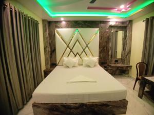 Un pat sau paturi într-o cameră la Hotel Maniraj Inn