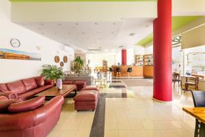 a lobby with couches and a table and chairs at Pegasus Hotel in Stalos