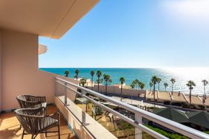a balcony with chairs and a view of the beach at Grande Real Santa Eulalia Resort & Hotel Spa in Albufeira