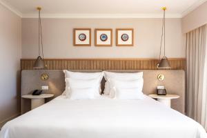 a bedroom with a large bed with white pillows at Grande Real Santa Eulalia Resort & Hotel Spa in Albufeira